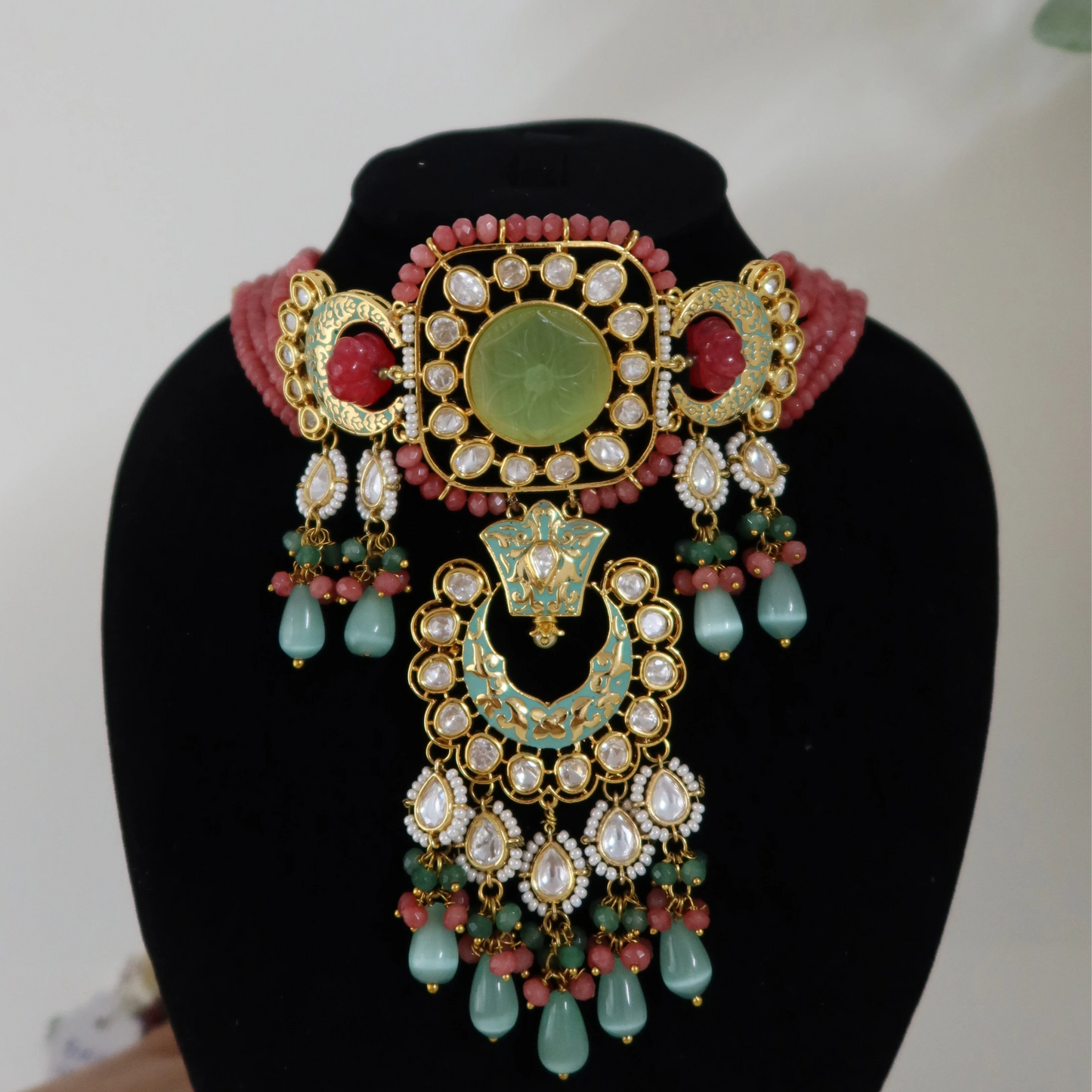 Decorative necklace on a black stand with a white background
