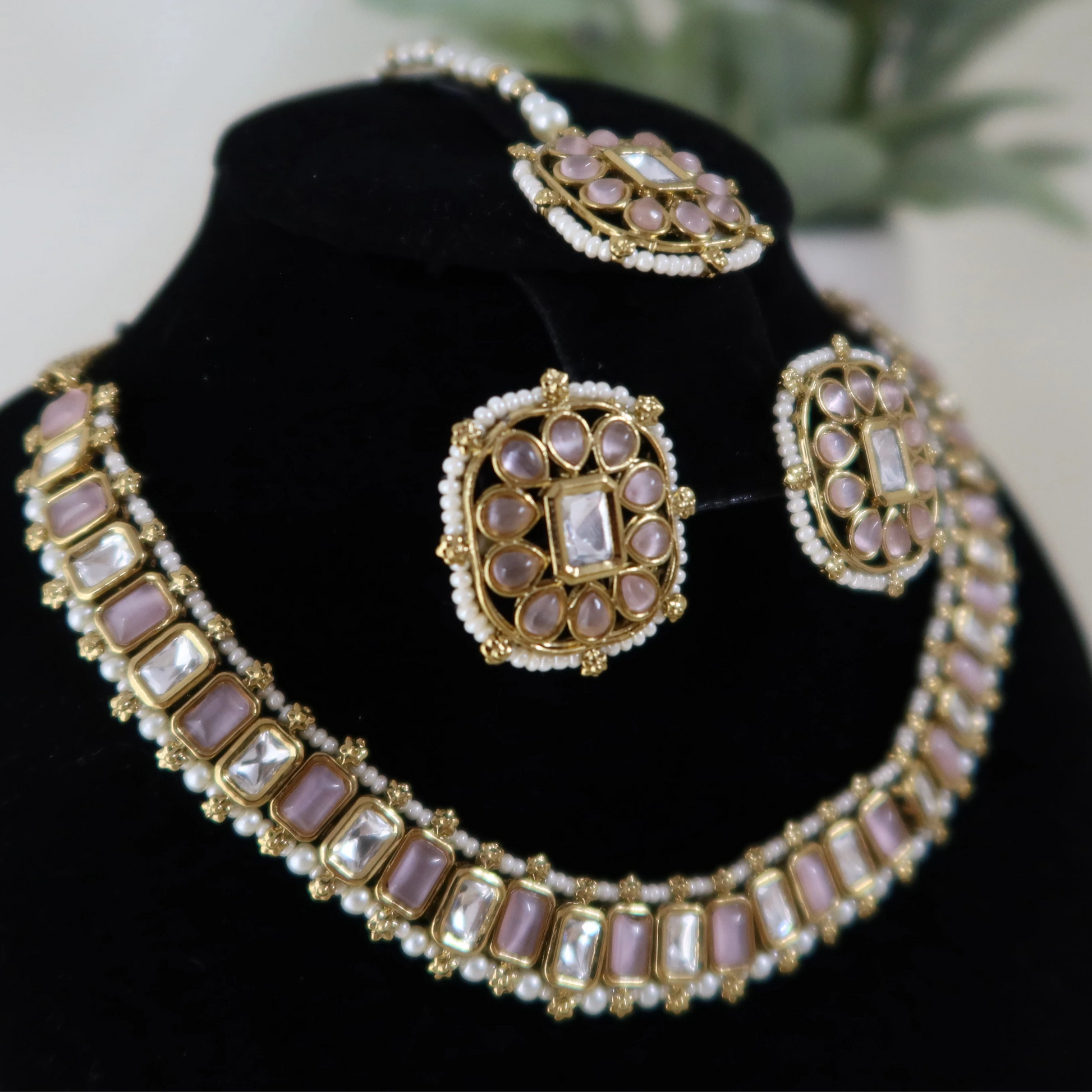 Jewelry set with necklace and earrings on a black stand