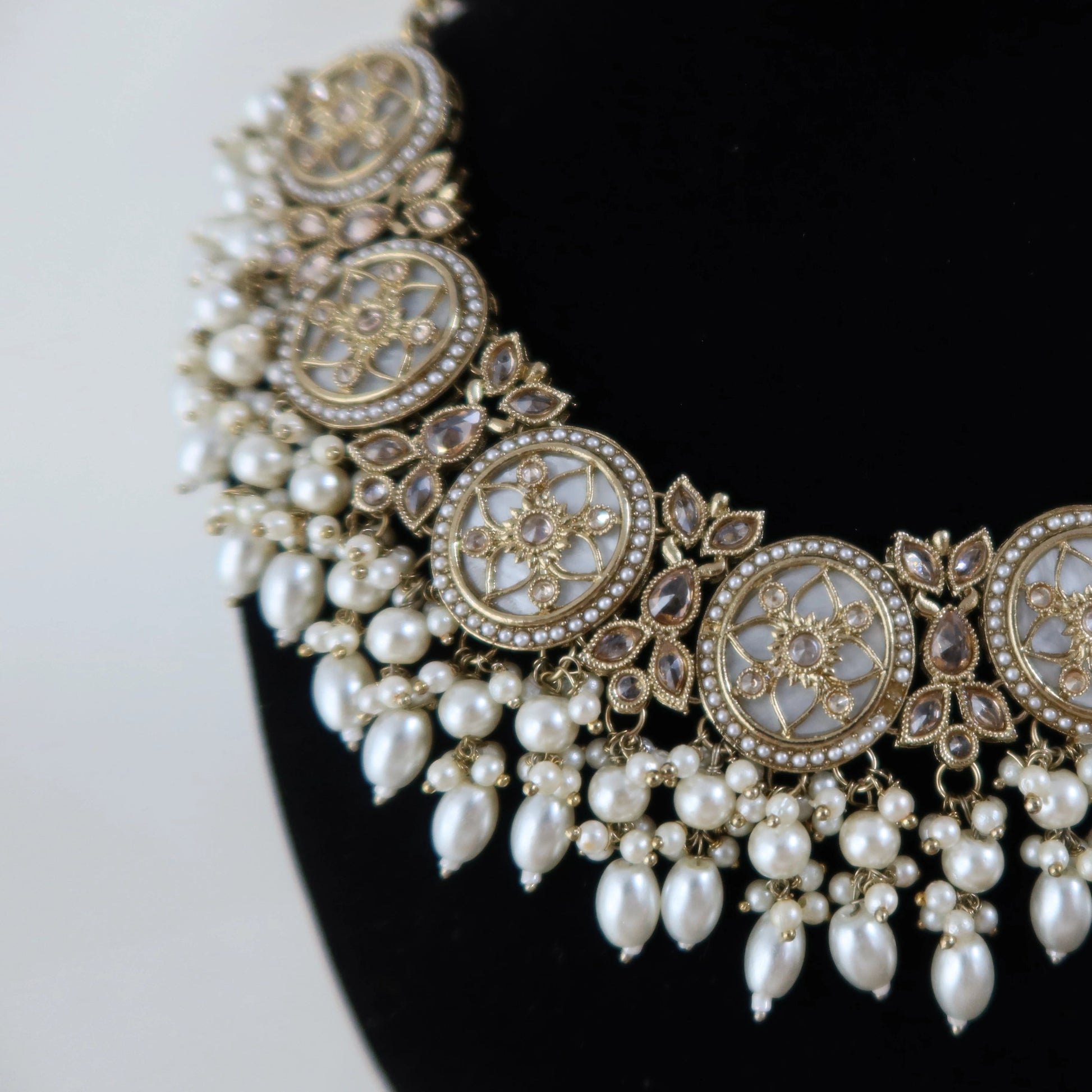 Decorative necklace with pearls and gold details on a black background
